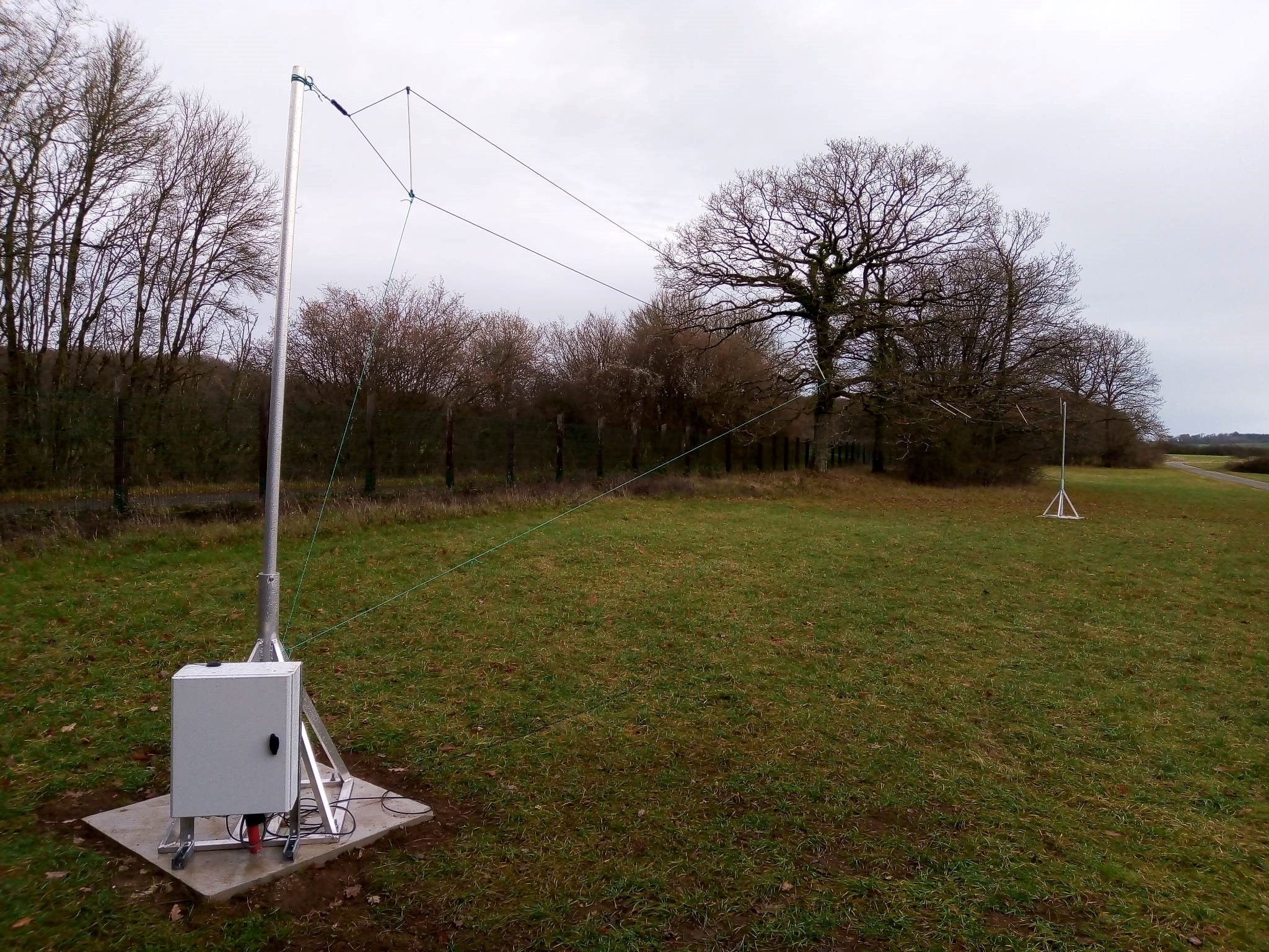 L'antenne émettrice à Dourbes (à gauche, 25 mètres de long), et l'antenne réceptrice sur le toit de l’IRM à Uccle (à droite, 1 mètre de diamètre).